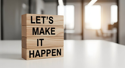 Let's make it happen message displayed on wooden blocks stacked on a white surface in a bright and modern office setting ready for success