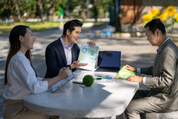 Business team discussing sustainability strategy outdoors in park