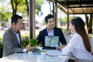 Business people discussing esg strategy outdoors with tablet