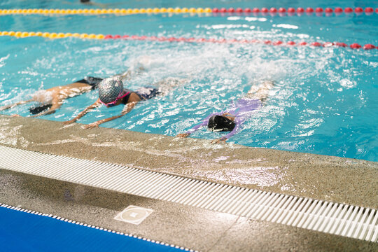 Children learning swimming techniques at indoor pool