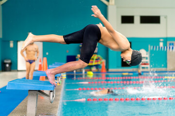 Young boy diving starting swimming race training