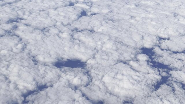 View from airplane flying above clouds &ndash; peaceful sky and soft sunlight over white cloudscape

