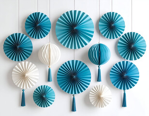 An elegant arrangement of teal blue and ivory paper rosettes and honeycomb lanterns with tassels for party decorations