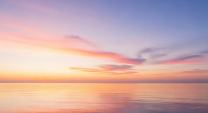 Serene ocean horizon at sunrise with soft pink and orange clouds