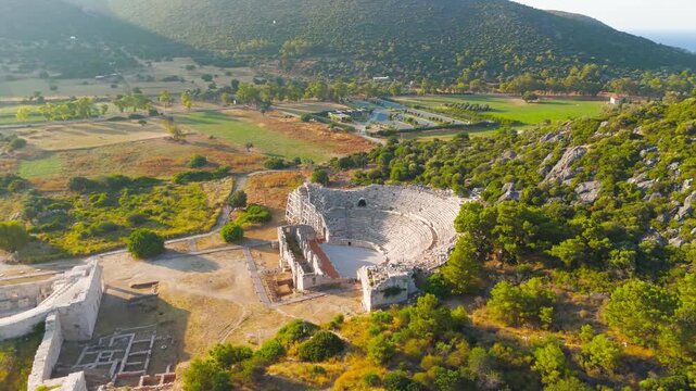 Gelemis, Turkey. Patara Ancient Theatre with 6000 capacity on Kursunlu Hill, monumental roman structure in summer morning. Aerial View, MasterShots, Spiral forward