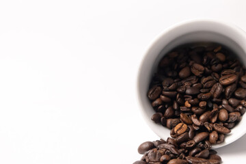 coffee beans falling out of a white cup