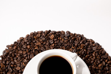 Cup with hot coffee and coffee beans below on a white background