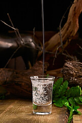 Pouring clear white liquor into the wine vessels placed on the wooden board creates countless...