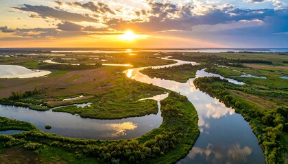 Aerial view of a winding river at sunset, reflecting warm colors