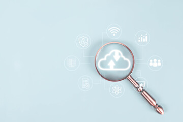 Magnifying glass focusing on glowing cloud computing icon with technology network symbols on light blue background, representing data analysis, cloud storage, cybersecurity, and digital innovation