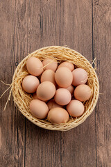 A bamboo basket with a wooden background is filled with delicious fried eggs.