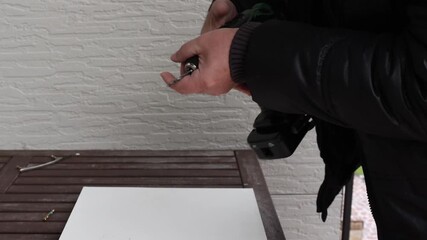 Man's hands remove battery from cordless power drill after use. High quality 4k footage