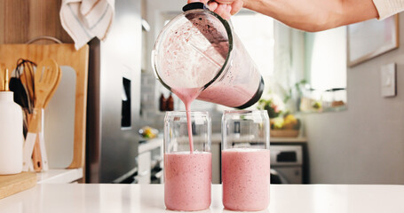 Hand, pour smoothie and glasses in kitchen with blender, organic nutrition and antioxidant...