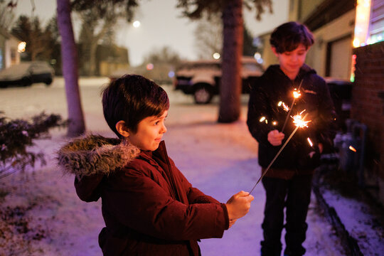 Two young boys having fun with bengal lights on New Year's Eve