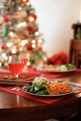 Christmas dinner and non-alcoholic drink on table with lights in background