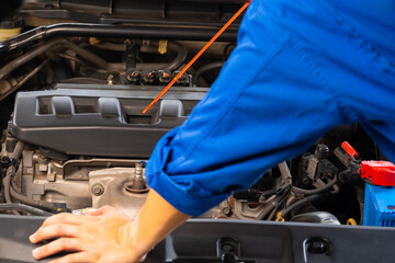 Car maintenance technician He is checking the auto engine, car inspection center.	