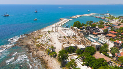 Side, Manavgat, Turkey. Temple of Apollo and Athena under bright summer sun, ancient harbor and South Basilica ruins on Mediterranean coast. Aerial View