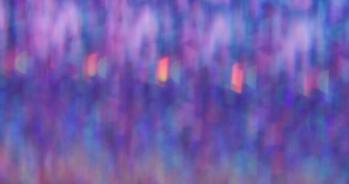 Defocused crystal flicker. Shimmering glow texture. Rainbow bokeh light mix color. Faceted prism sparkling abstract purple blue neon background.