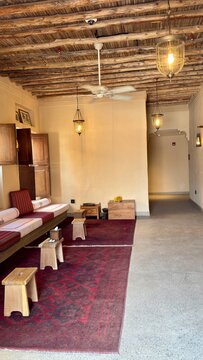 This interior space, reminiscent of a traditional Middle Eastern or Arabic majlis guest room, offers a rich, cultural ambiance. Key features include a striking exposed ceiling made of natural, rustic 