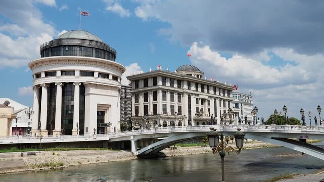 Scenic view of Archaeological Museum of Macedonia with elegant neoclassical columns and dome standing in Skopje by Vardar River on bright summer day
