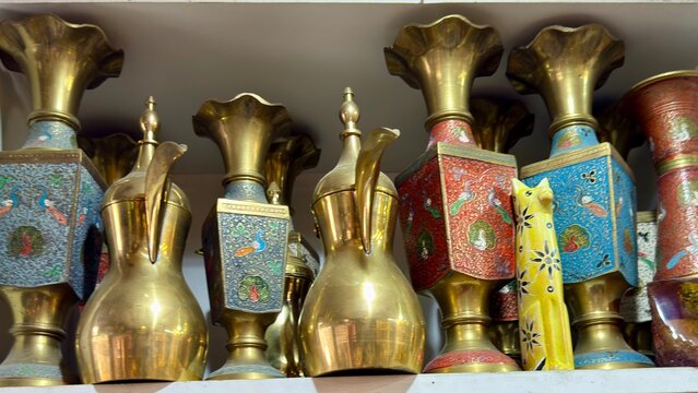 A collection of antique items including musical instruments, decorative objects, lamps, books, and various accessories displayed on a table, creating a vintage atmosphere."antique lantern in dubai Al 