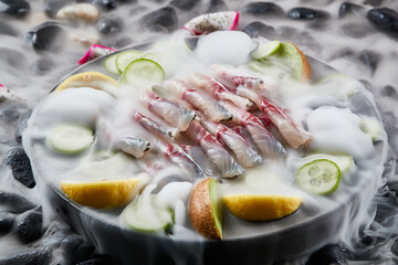 Arrange the glistening, white slices of fresh fish on a black round porcelain plate.