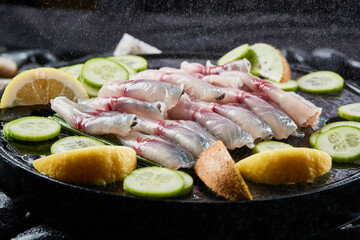Arrange the glistening, white slices of fresh fish on a black round porcelain plate.