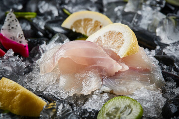 Arrange the glistening, white slices of fresh fish on a black round porcelain plate.