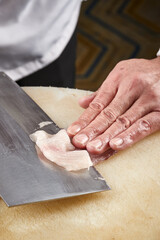 On a white cutting board, the chef demonstrates his exquisite knife skills in cutting and slicing sashimi and fresh fish.
