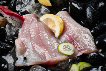Arrange the glistening, white slices of fresh fish on a black round porcelain plate.