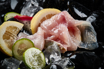 Arrange the glistening, white slices of fresh fish on a black round porcelain plate.