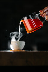 Steam from hot herbal tea cup in cozy atmosphere and soft light