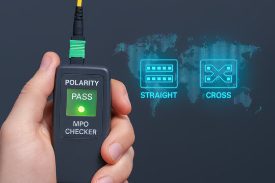 Fiber optic technology testing device with polarity checker held in hand passing signal with digital network icons and world map background