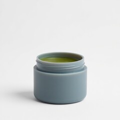 Small gray jar filled with green balm on white background