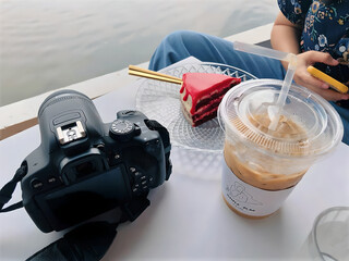 Coffee and cake with camera on table by the river, relaxing lifestyle and photography moment