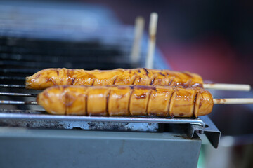 Savory glazed skewers cooking on a grill outdoors