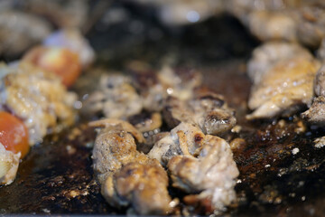 Sizzling meat skewers cooking on hot grill surface