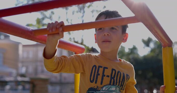 Young boy prepping himself to climb across monkey bars - close up