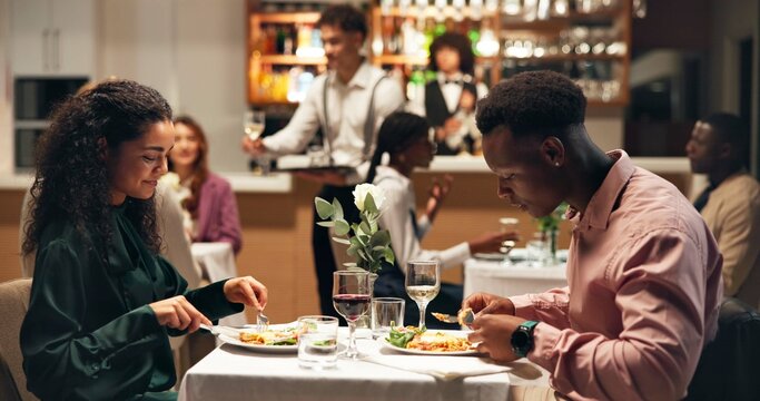 Couple, eating dinner and night at restaurant on date, bonding or happy for fine dining with lasagna. Woman, man and relationship, food and gourmet meal with customer experience with cuisine at diner