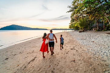 Family walk on the beach on Koh Chang island in Thailand 