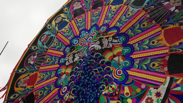 Low angle view of colorful handmade peacock kite displayed at Sumpango festival