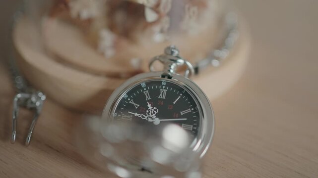 classic silver pocket watch resting on wooden surface with soft light