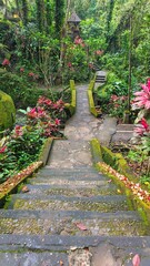 Stone steps lead through lush greenery at Goa Gajah Temple in Bali, creating a serene and natural pathway.