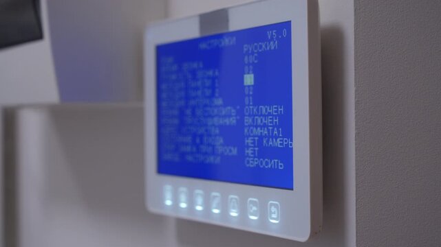 A home intercom system is activated, its screen and buttons glowing. The device rings with the sound of a classic landline telephone.