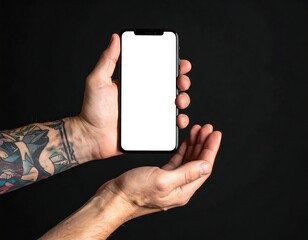Close-up of hands holding a smartphone with a blank screen, against a black background. One arm is tattooed