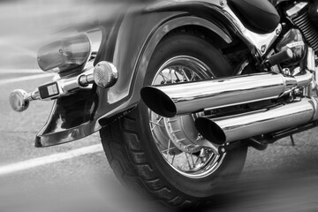 Motorcycle Rear Wheel and Chrome Exhaust, Black and White Close-Up