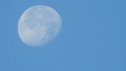 The Moon floats quietly in a vast blue sky. A minimalistic image evoking feelings of solitude, dreams, stillness, and infinity. Ideal for conceptual or emotional designs.