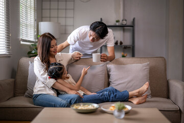 Asian family relaxing on sofa enjoying quality time