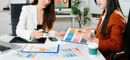 Creative female designers team using pen tablet and color palette working in graphic design Choose colors for working on tablets and computer designs.