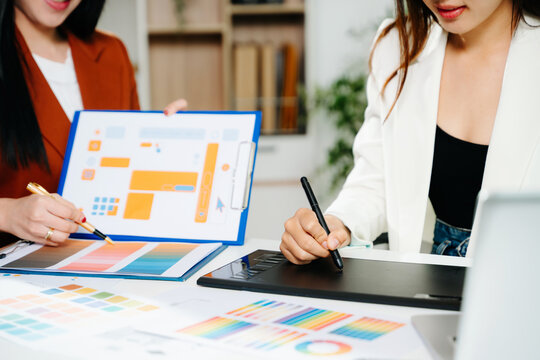 Creative female designers team using pen tablet and color palette working in graphic design Choose colors for working on tablets and computer designs.